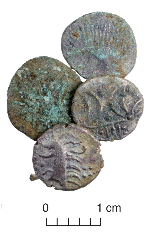 Image shows four old coins each around 1 centimetre in diameter. The coins featuring raised designs and are laid out in a diamond shape