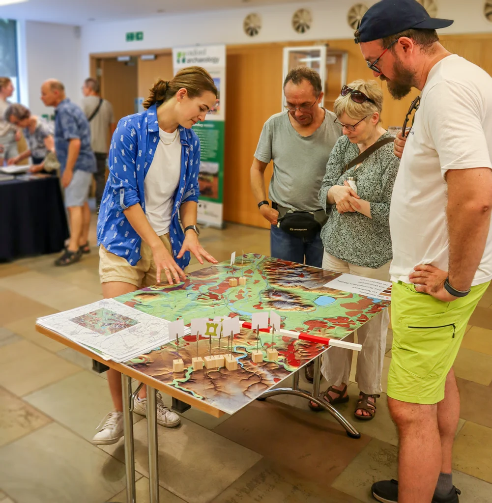 Members of the public look at a lidar map of local archaeology. 