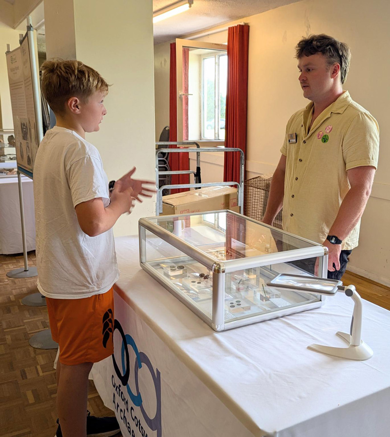 Photo of a young boy speaking to an OCA staff member in front of a display case