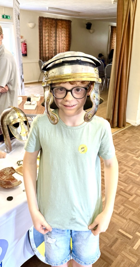 Photo of a young boy wearing a replica Roman helmet