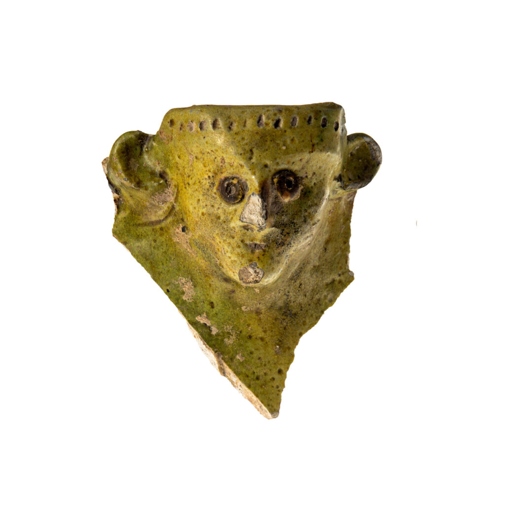 green glazed pottery with molded face